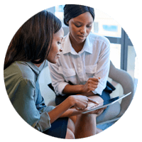 Businesswomen sit and use tablet device