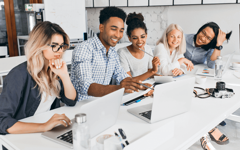 Group of modern business professionals work together on various devices