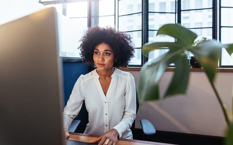 Businesswoman on desktop computer looking at Renewals and Warranty platform