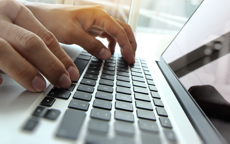 Close up of hands typing on keyboard