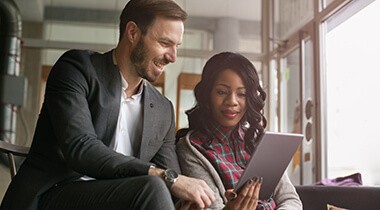 Man and a woman collaborating on a tablet