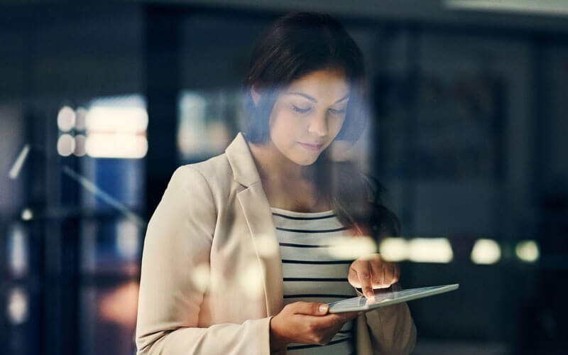 Business professional reading whitepaper off of tablet computer