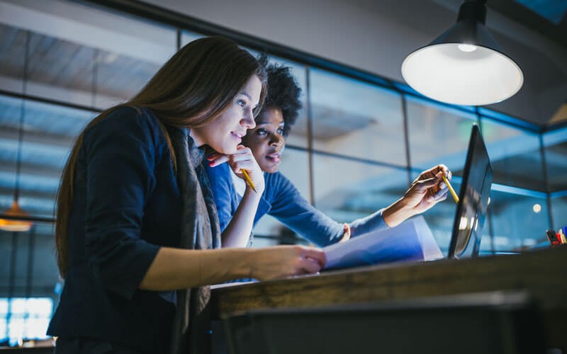 Two women working on laptop