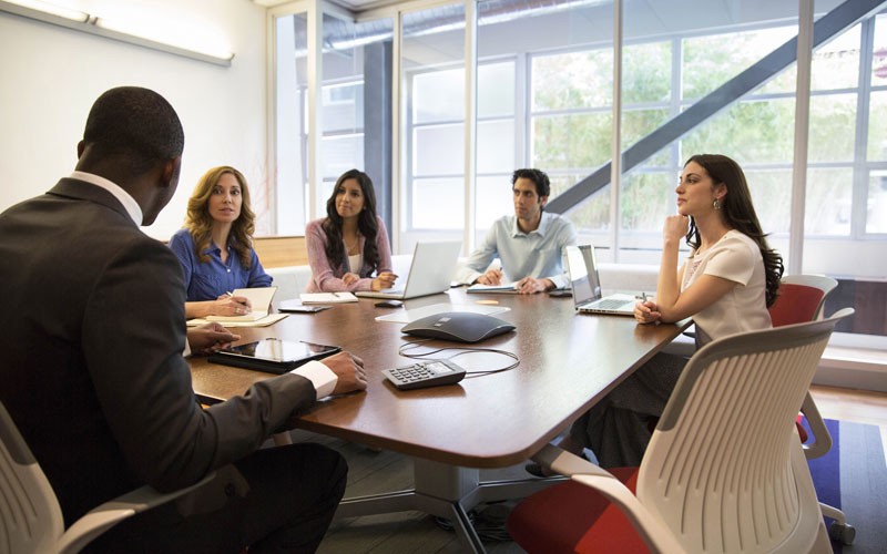 Conference room with people video conferencing.