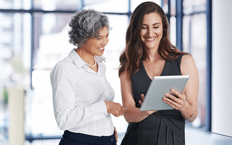 Two business professionals review IT strategy on tablet device
