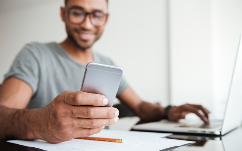 Smiling man in glasses is able to work anywhere anytime on his own device