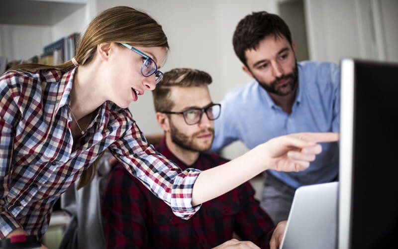 IT support professionals gather around computer to assess security 