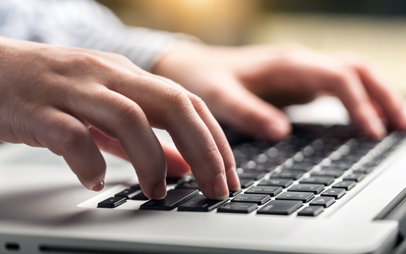 Close up of hands typing on laptop keyboard