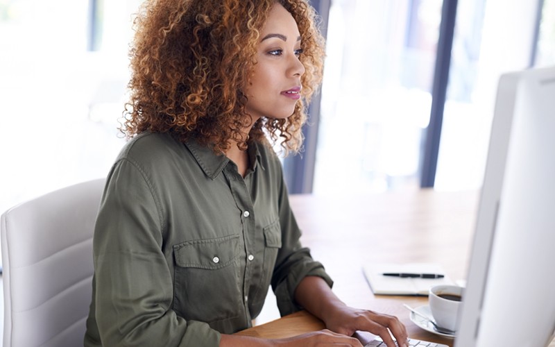 Businesswoman looking at budget information on desktop computer