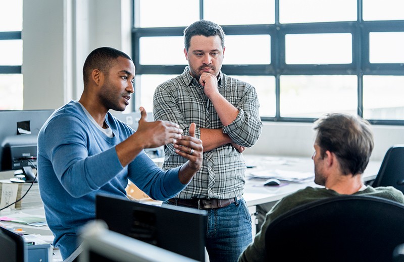 Three men having a discussion in office